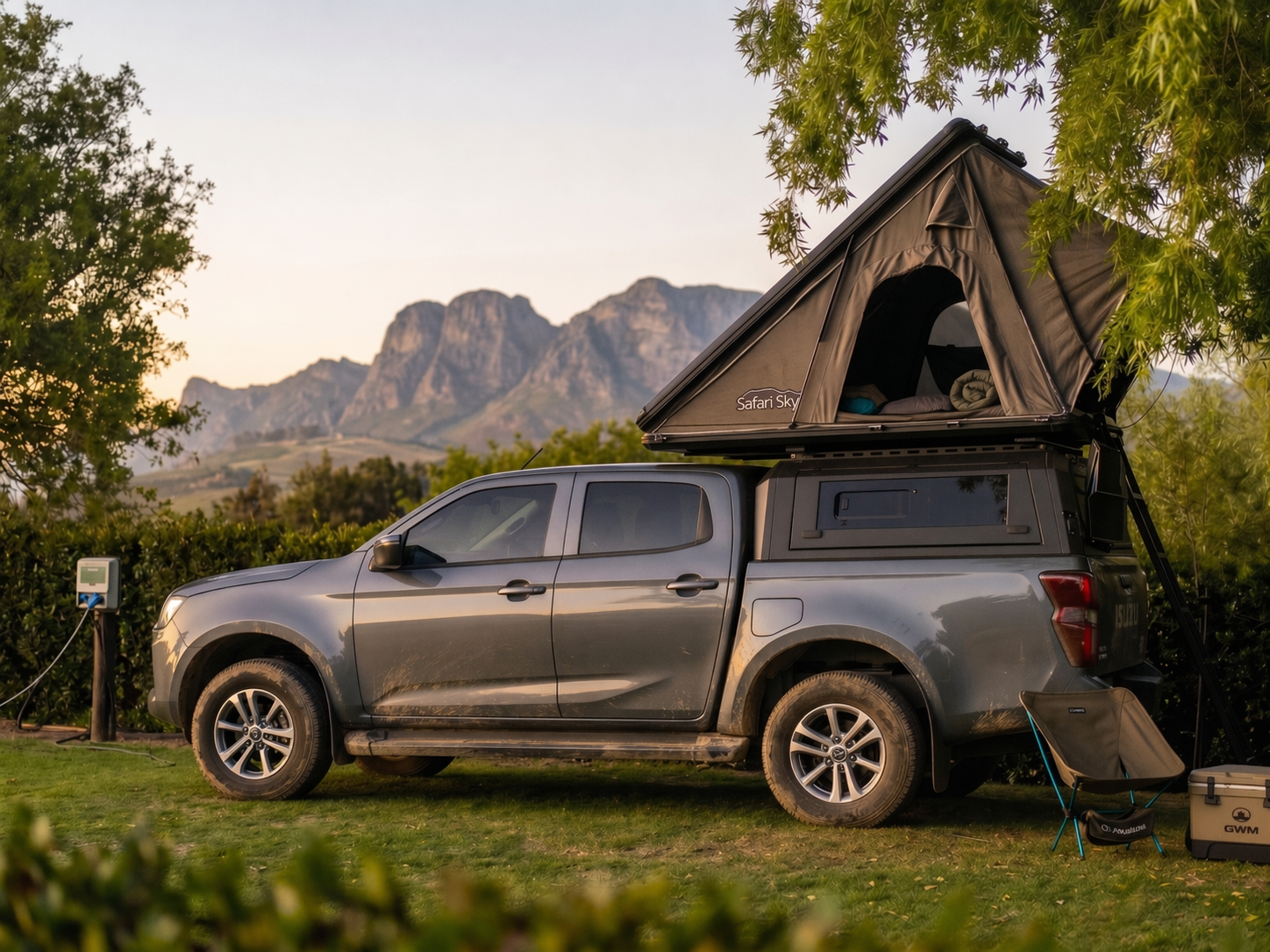 Safari Sky rooftop tent set up on a bakkie at sunset with mountains in the background